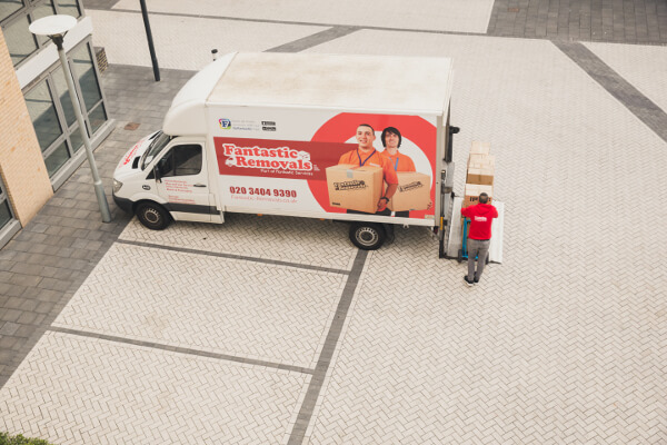 Aerial view of professional mover loading boxes into a removal service van.