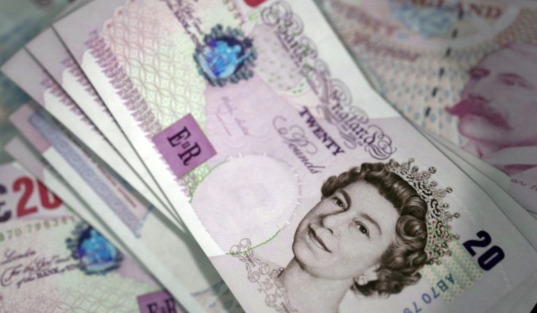 British pound sterling banknotes spread out on a surface.