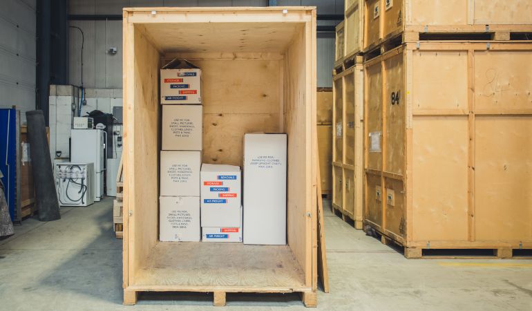 Boxes inside a wooden storage container in a warehouse.