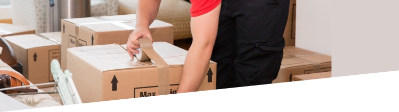 The image shows a Fantastic Removals specialist who is packing the belongings of a customer in a large box.