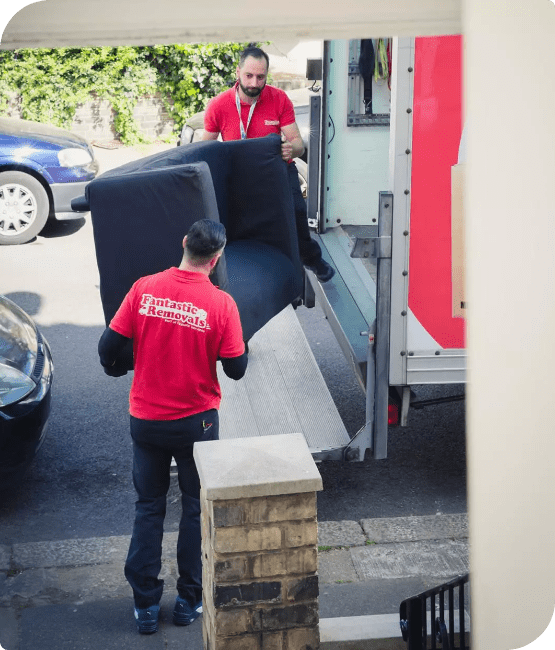 Picture of two furniture removalists loading a sofa into a removal van