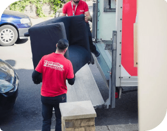 Picture of two furniture removalists loading a sofa into a removal van