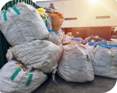 Commercial waste bags piled outside a building and prepared for commercial waste removal service.